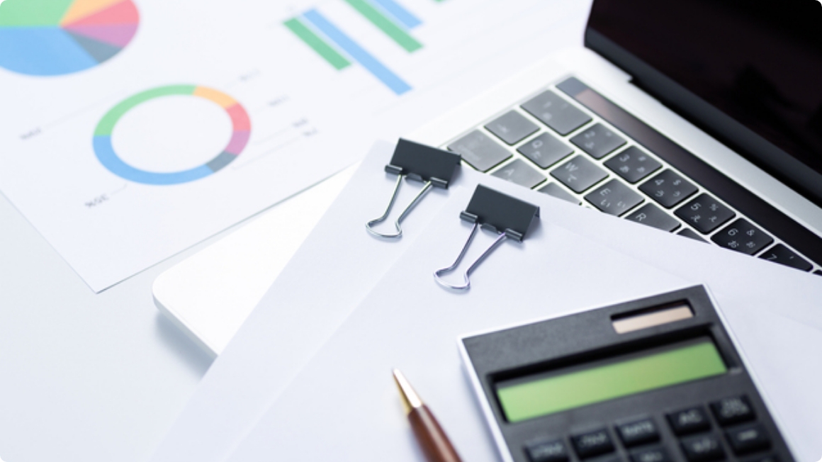 コストが記載された書類と計算機とラップトップ